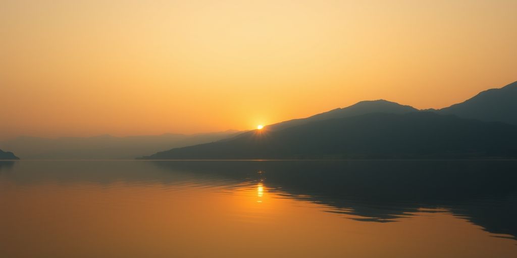 Sunrise over lake with mountains.